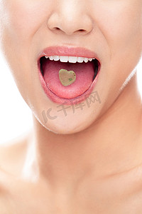 舌头上有颗心形糖的青年女人嘴部特写