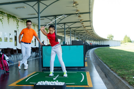 练习场上教练指导女童打高尔夫
