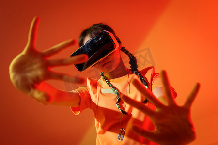 科技橙色摄影照片_戴着VR眼镜的个性年轻女孩