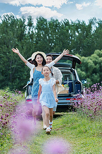 奔跑女孩摄影照片_在花海里奔跑的幸福家庭