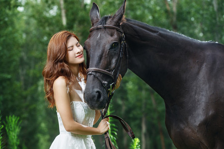 树林中漂亮的青年女人和马