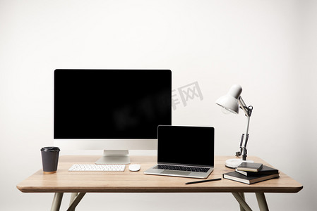 workplace with lamp, coffee to go, notebooks, desktop computer and laptop with copy space isolated on white