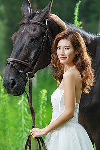 草丛中漂亮的年轻女人和马