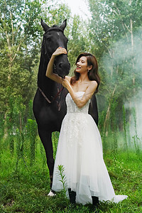 树林里漂亮的年轻女人和马