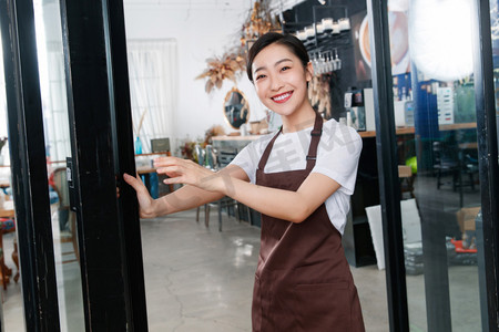 咖啡店门口迎接顾客的女服务员