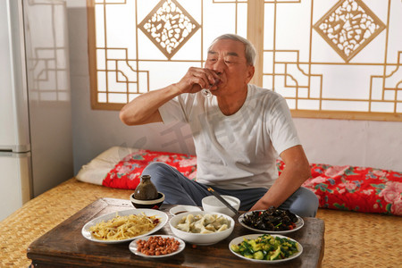 吃饭乡村摄影照片_老年人坐在家里喝酒吃饭