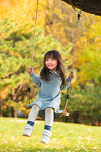 3岁到4岁摄影照片_在公园里荡秋千的快乐女孩