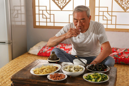 房屋元素摄影照片_老年人坐在家里喝酒吃饭