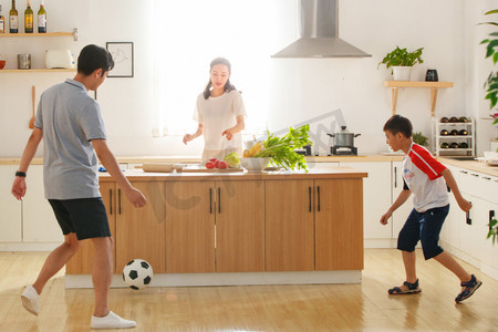 踢足球图片摄影照片_父亲和儿子在家踢足球