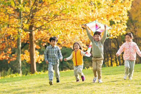 小朋友手拉手画摄影照片_快乐的小朋友在公园里放风筝