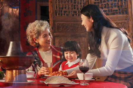 一家人吃饭摄影照片_青年女人带孩子陪母亲吃饭
