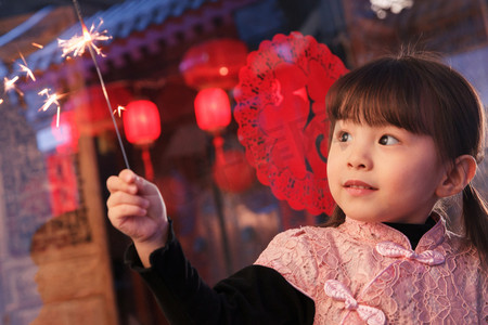 中式剪纸剪纸摄影照片_手拿烟花的可爱小女孩