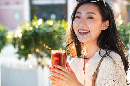 快乐的青年女人品尝夏日饮品