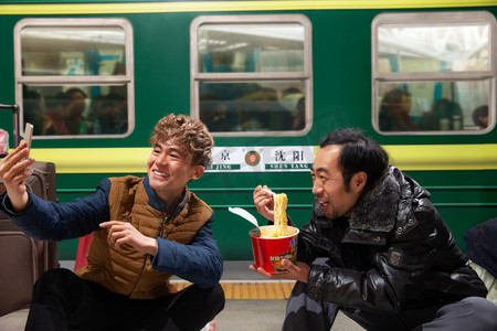 年货北京摄影照片_两名男子在火车月台上看手机