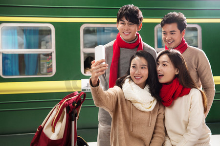 青年男女在火车站台上用手机