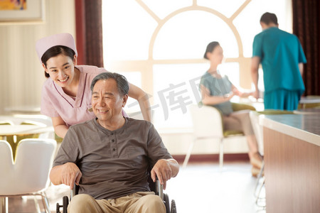职业女人摄影照片_护士推着坐轮椅的老年人