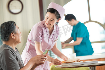 康复护理摄影照片_护士照顾老年人用餐