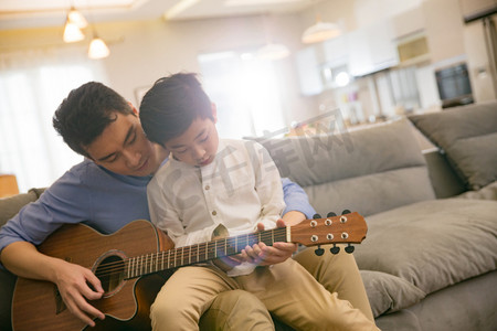亲子活动图片摄影照片_父亲和男孩在弹吉他