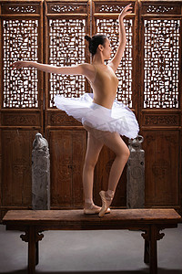 古代女人摄影照片_青年女人在中式古典门前跳芭蕾舞