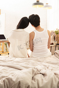 幸福的情侣坐在床上的背影