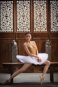 古典芭蕾舞摄影照片_青年女人在中式古典门前跳芭蕾舞