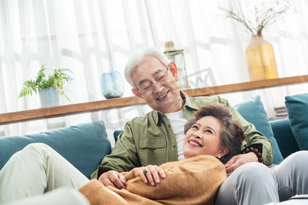 快乐的中老年生活摄影照片_沙发上幸福的中老年女士躺在丈夫腿上