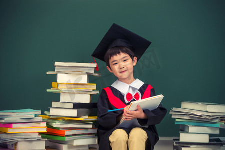 大量物体摄影照片_穿着学士服的小学男生