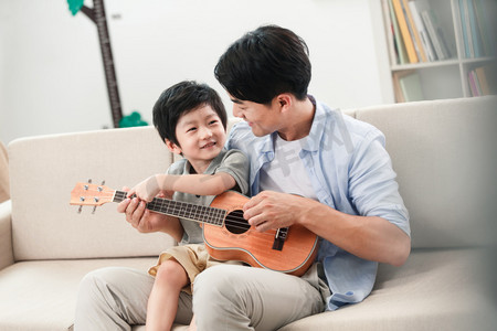 快乐的父子在弹吉他