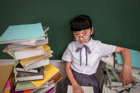 坐在书堆里的小学女生