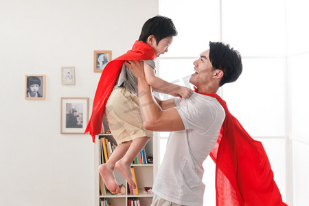 高能英雄摄影照片_快乐的父子在扮演超人