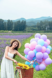 夏季图片摄影照片_青年女人在花海里骑自行车