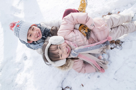 冬天小朋友摄影照片_两个小朋友在雪地里玩耍