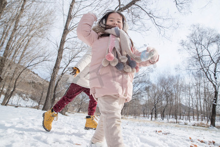 冬天小朋友摄影照片_两个小朋友在雪地里玩耍