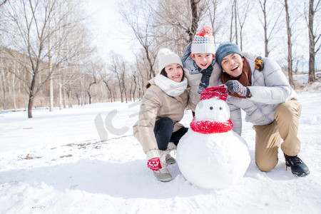 亚洲雪摄影照片_一家三口在雪地里堆雪人