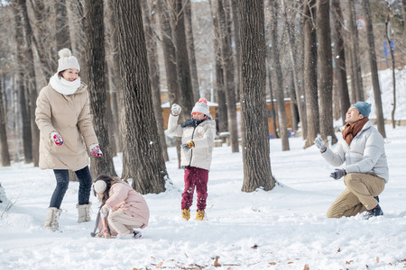 亚洲雪摄影照片_雪地里打雪仗的一家人