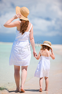 母亲和女儿沙滩上散步