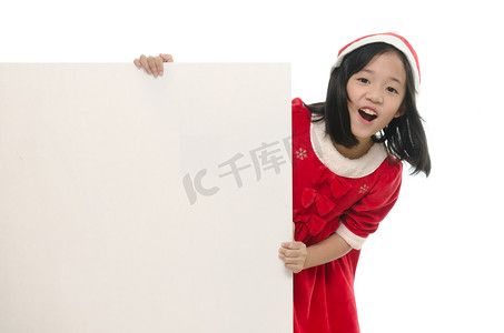 美丽的亚洲女孩在圣诞老人服装与白板