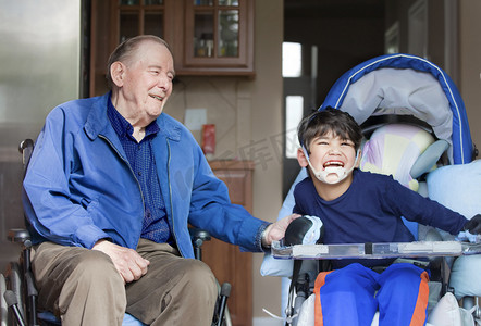 残疾人爷爷摄影照片_老人的轮椅笑与禁用在厨房里的男孩