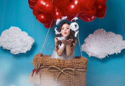 风吹儿童摄影照片_小可爱的女孩，在红色的心形气球情人节飞