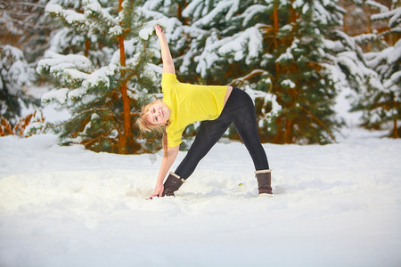 yoga摄影照片_美丽的女人在户外在雪做瑜伽 