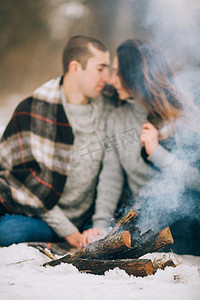 pi摄影照片_年轻的女人和男人的前面吸烟篝火在冬天 pi