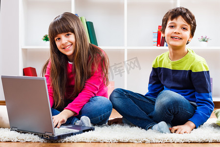 可爱的小女孩和小男孩使用的笔记本电脑