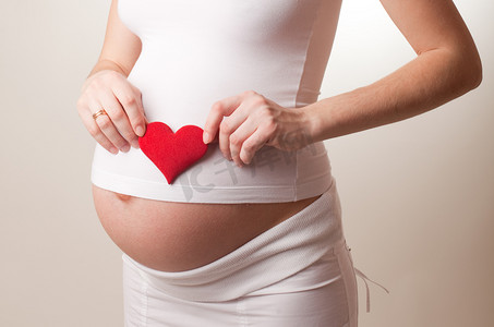 红色的的心摄影照片_怀孕的女人放玩具心