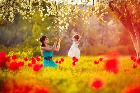 开春摄影照片_ 幸福的女人和孩子在盛开春 garden.mothers 天