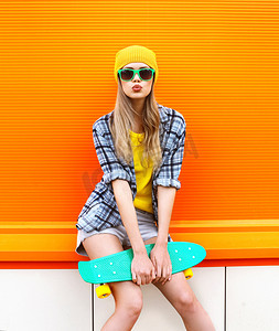 时尚潮人酷女孩在太阳镜和颜色鲜艳的衣服机智
