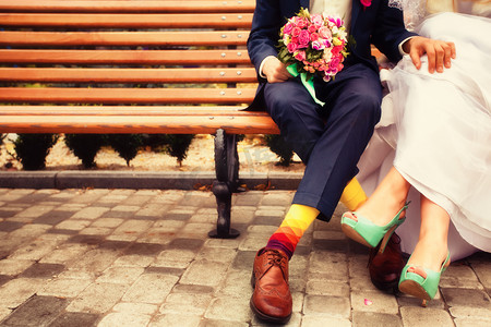新娘和新郎穿着鲜艳的衣服坐在长椅上