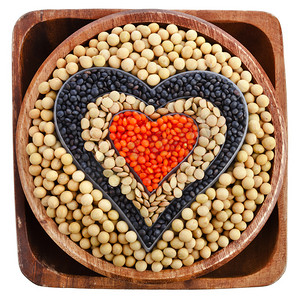 soybean and a variation of lentils in a wooden bowl isolated on white background