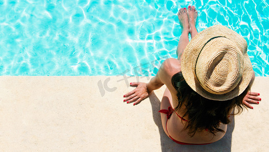 女人坐在一个游泳池与初七