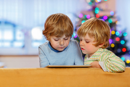两个快乐的小孩，tablet pc，在室内玩
