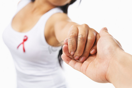 女人握着的手给支持艾滋病事业或乳房会在墨西哥海滩